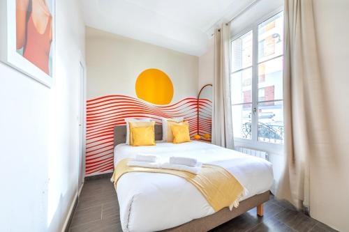 une chambre avec un grand lit avec des oreillers jaunes dans l'établissement Appartement coloré 14ème arrondissement- IV, à Paris