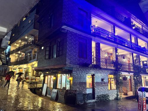 Eine Gruppe von Menschen, die nachts auf einer Straße spazieren in der Unterkunft Bayith Inn,dragon chowk in Manali