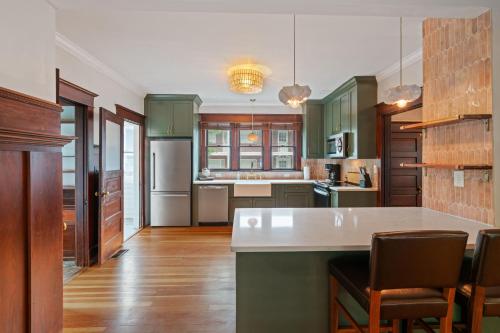 a kitchen with green cabinets and a white counter top at Historic Heart Of Downtown House in Vancouver