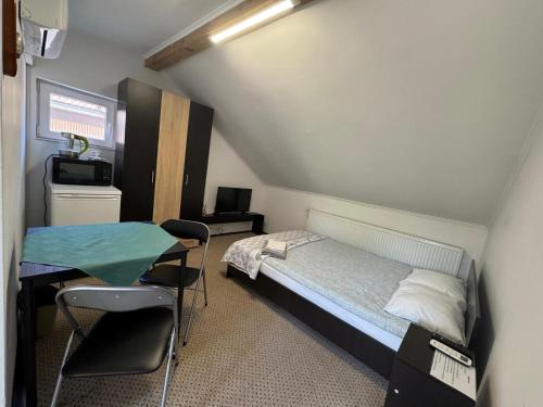 a bedroom with a bed and a table and chairs at Elizabeth's Rooms in Gherla