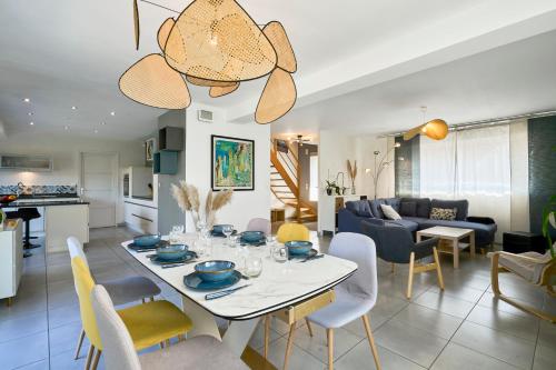 une salle à manger et un salon avec une table et des chaises dans l'établissement La Familiale - Les Demeures d 'Adrien, à Santes