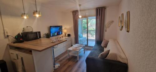 un salon avec un canapé bleu et une table dans l'établissement Location appartement bord de mer, à Six-Fours-les-Plages