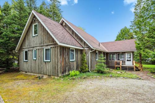 a small wooden house with a porch at Lakeview Loft A-frame Escape Tobermory in Tobermory