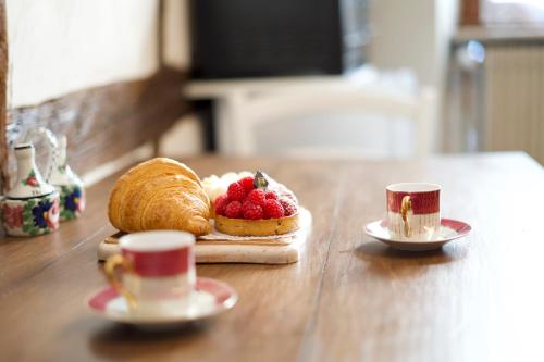 une pâtisserie aux baies sur une table avec deux tasses dans l'établissement L'Escapade Fleurie - petite Venise - 2 people, à Colmar