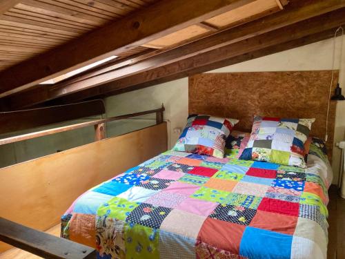 a bed with a colorful quilt on it in a room at Casa Medieval de Nisa in Nisa