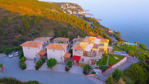 an aerial view of a house on a hill next to the water at Koumaros Villas in Agia Paraskevi