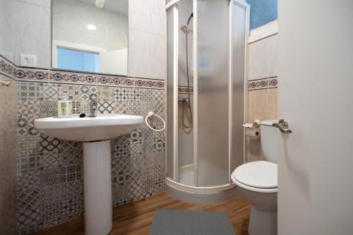 a bathroom with a shower and a sink and a toilet at Little Yellow House in Gijón