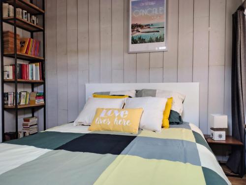 un lit avec un oreiller qui dit « j'aime c'est détester » dans l'établissement Charmante cabane de pêcheur, à Cancale