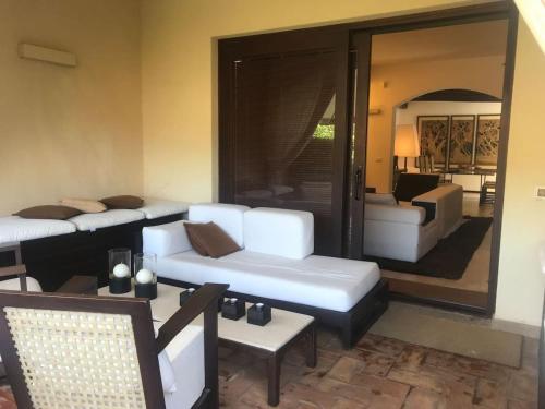 a living room with white couches and a room with a view of a bedroom at Beautiful luxury villa located in Sardinia in Villasimius near the beaches in Gesturi