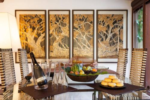 a table with a bowl of fruit and a bottle of wine at Beautiful luxury villa located in Sardinia in Villasimius near the beaches in Gesturi