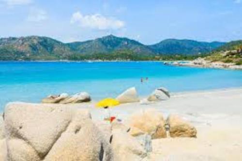 a beach with rocks and the blue water at Beautiful luxury villa located in Sardinia in Villasimius near the beaches in Gesturi