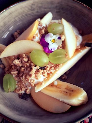 Un plato de comida con fruta y una flor encima. en B&B De Geythoek, en Sijsele