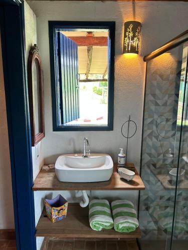 a bathroom with a sink and a mirror at Chalé Frida Kahlo in Campinas