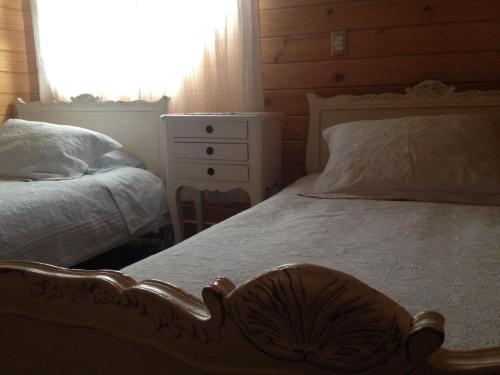 a bedroom with two beds and a dresser at B&B de German in Pucón