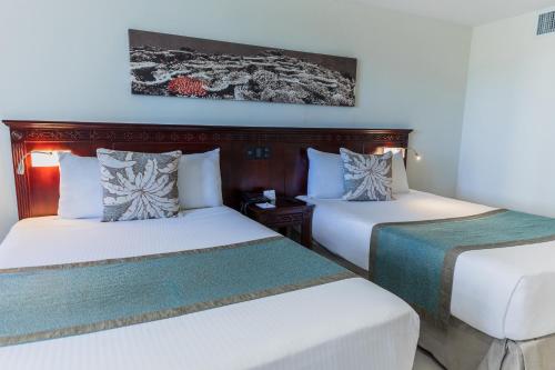 two beds sitting next to each other in a room at Dominican Fiesta Hotel in Santo Domingo