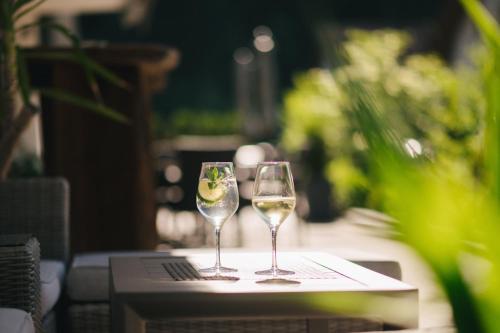 two glasses of white wine sitting on a table at Hotel Fronza - your hike & mountain home in Lutago