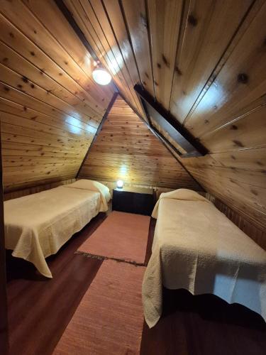 a room with two beds in a wooden cabin at Casa Rosa in Camacha