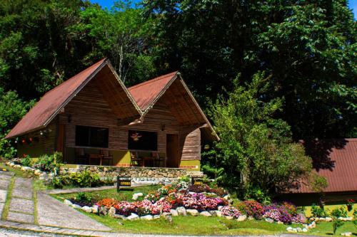 a small wooden house with flowers in front of it at TREE TREK BOQUETE Adventure Park in Boquete