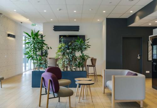 a lobby with chairs and plants at B&B Hôtel Thionville Centre Gare Porte du Luxembourg A31 in Thionville