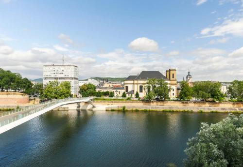 a bridge over a river with a city in the background at B&B Hôtel Thionville Centre Gare Porte du Luxembourg A31 in Thionville