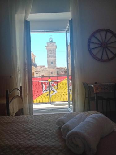 a bedroom with a window with a view of a clock tower at bed & breakfast Acquaviva di Vullo Vincenzo in Acquaviva Platani