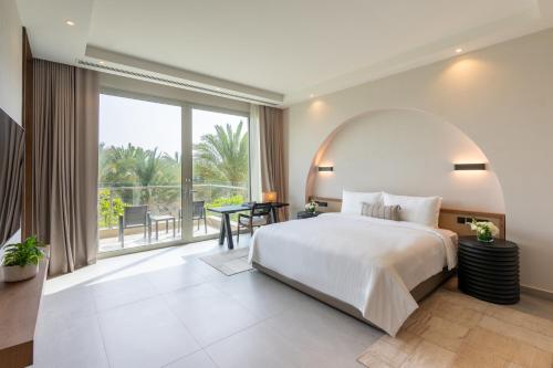 a bedroom with a large bed and a large window at Rixos The Palm Hotel & Suites - Ultra All Inclusive in Dubai