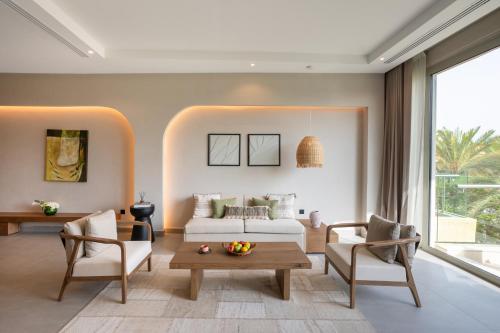 a living room with a couch and a table at Rixos The Palm Hotel & Suites - Ultra All Inclusive in Dubai
