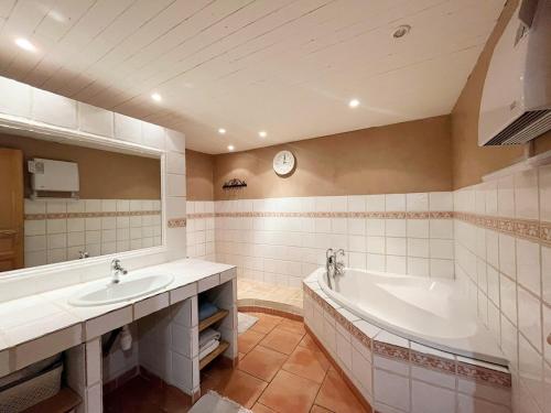une salle de bain avec une baignoire, un lavabo et un miroir dans l'établissement Charmante maison de hameau, à La Londe-les-Maures