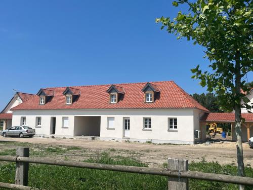 a large white house with a red roof at Camping la Haie Penée **** in Saint-Quentin-en-Tourmont