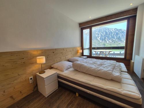 une chambre avec un lit avec une grande fenêtre dans l'établissement Tignes: Beau 2 Pièces Cabine, 4 Pers, Face aux Pistes, Balcon, WIFI - FR-1-502-598, à Tignes