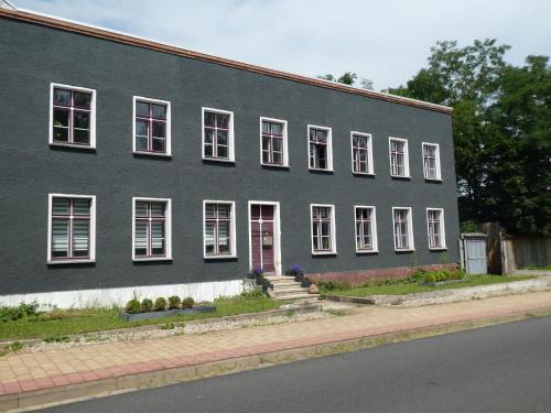 a black building with white windows and a red door at Wochenend-Auszeit in Möckern