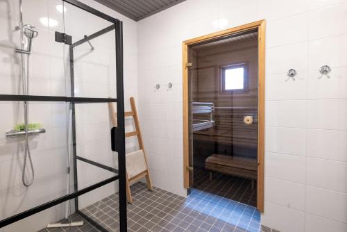 een badkamer met douche en glazen deur bij Villa Ankkuri in Hanko