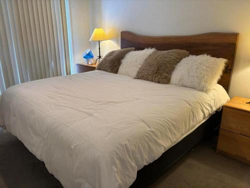 a bedroom with a bed with white sheets and pillows at Pico F101 in Killington