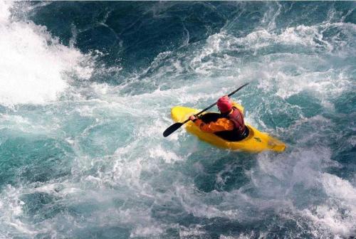 a person in a yellow kayak in the water at ZEcamping 3 étoiles animaux acceptés restaurant et Canoë Kayak in Aigueblanche