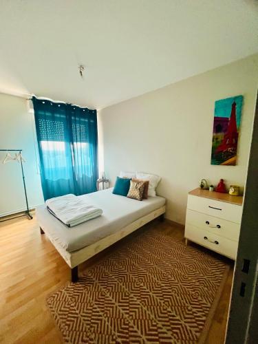 a bedroom with a bed with a rug and a dresser at Appartement agréable spacieux in Clermont-Ferrand