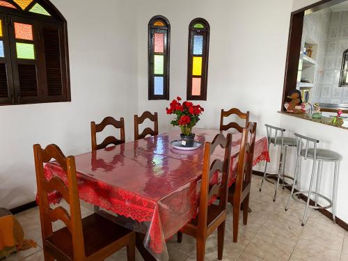 a dining room with a table and chairs with flowers on it at Casa com Wi-Fi proximo a Ilha de Itaparica in Ponta da Areia