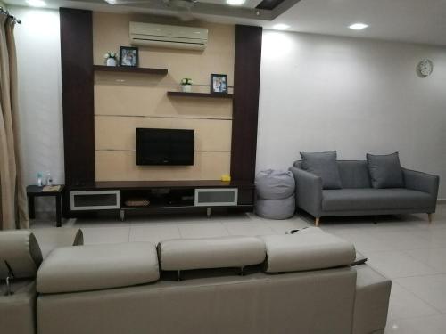 a living room with a couch and a flat screen tv at Putra Impiana Puchong in Puchong