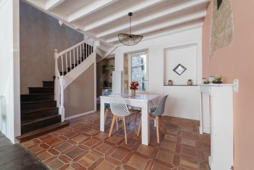 une cuisine et une salle à manger avec une table et des chaises dans l'établissement La Bonbonnière maison de ville 10 personnes, à Sanxay