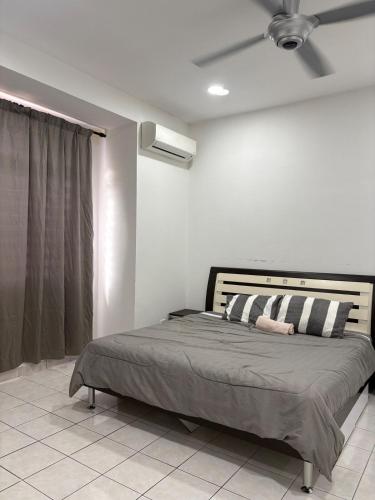 a bedroom with a bed with a ceiling fan at Putra Impiana Puchong in Puchong