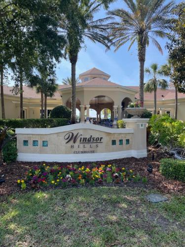 a sign in front of a building with palm trees at Family Friendly II in Orlando