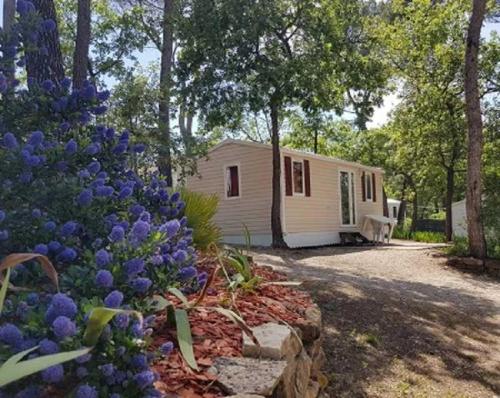 a mobile home in the woods with purple flowers at Camping 3 étoiles - Piscine - ccbbhgd in Peynier