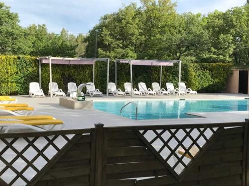 a swimming pool with white chairs and a table at ZEcamping 3 étoiles toboggans piscine locatif 25m2 5 pers in Peynier