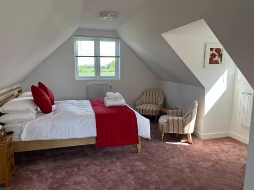 a bedroom with a bed with a red blanket at Rubys cartlodge in Stambourne