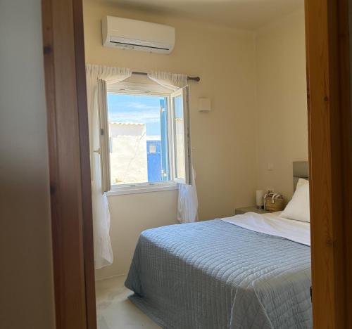 a bedroom with a bed and a window at Apleton Beach House Kimolos at Zacharias Beach in Kimolos