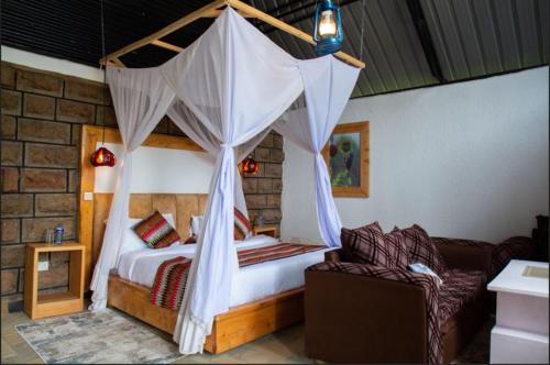 a bedroom with a bed with a mosquito net at Saba House and Lodges in Machakos