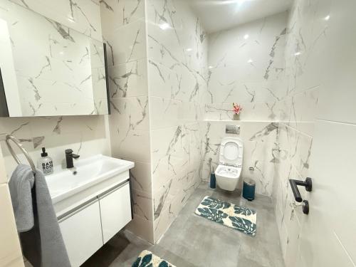 a white bathroom with a toilet and a sink at Beautiful apartment at point E, Dakar in Dakar