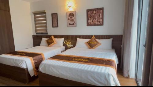 two beds sitting next to each other in a room at Cozy Villa V3G08A in Sonasea - Vân Đồn - Gần biển- cho thuê lẻ phòng in Thâm Câu