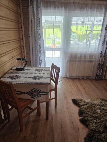 a table and chair in a room with a window at Grota zbójnicka apartament i pokoje in Gliczarów