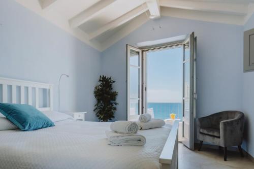 a bedroom with a bed with a chair and a window at Vento d'Estate B&B in Portoscuso