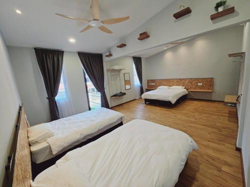 a bedroom with two beds and a ceiling fan at Gold Plus Homestay 5970 in Kuantan
